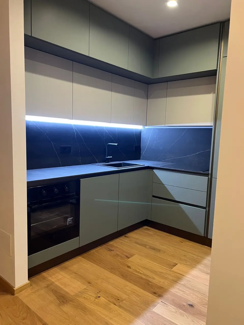 Sage green kitchen with dark worktop