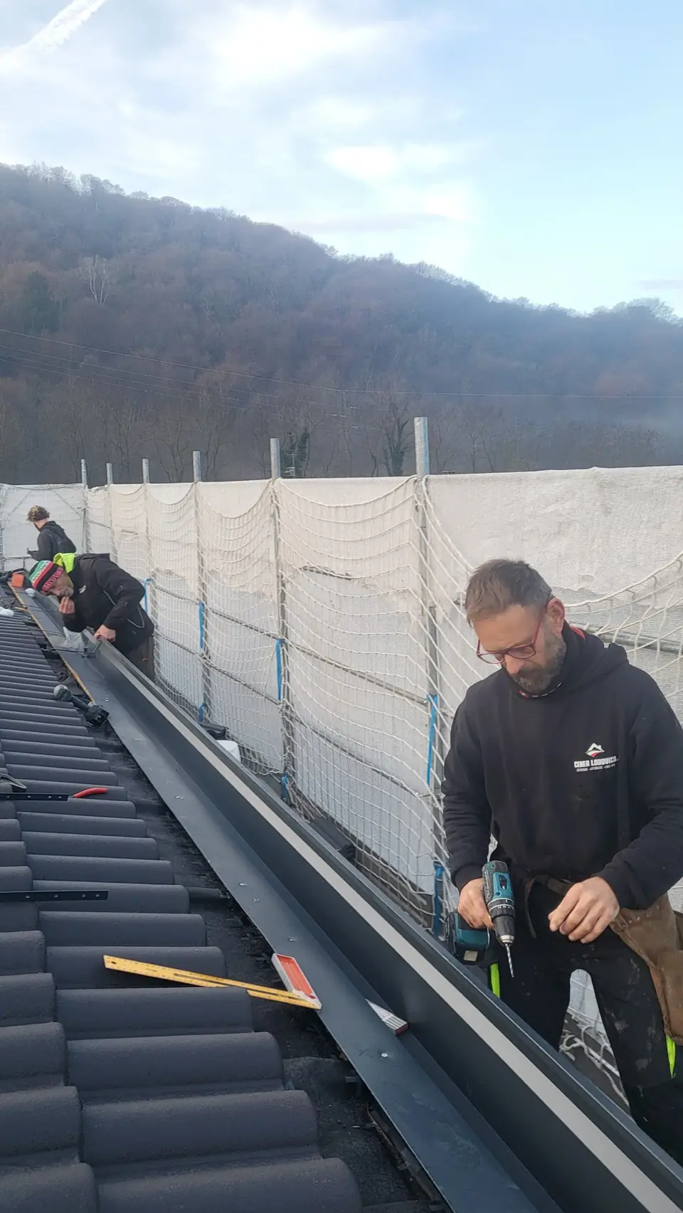 Workers on a roof gutter